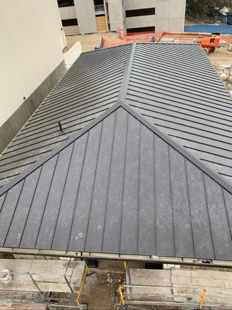 Commercial metal roof construction with crane equipment in Palm Springs North